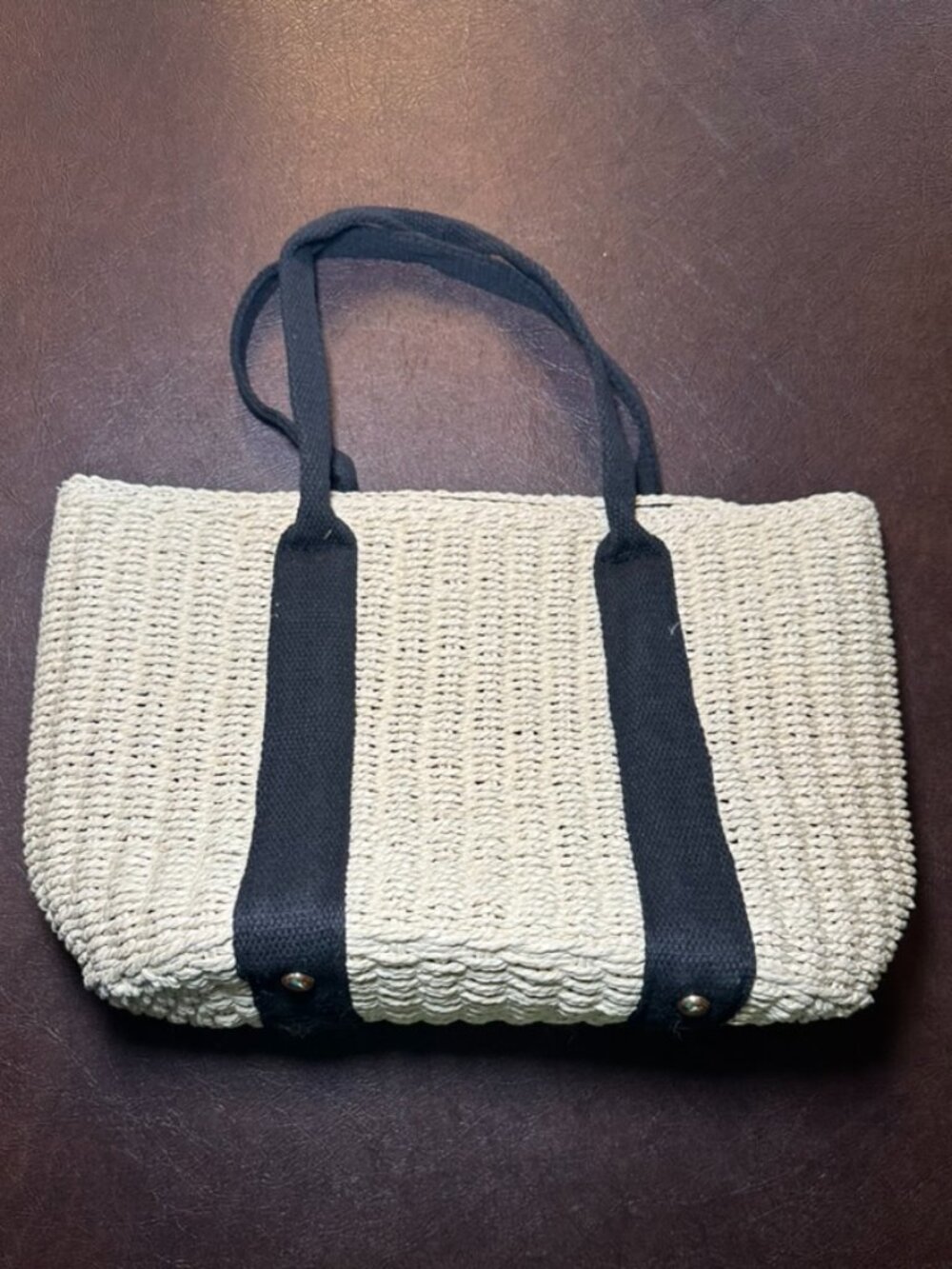Straw tote with black fabric strap and lining.